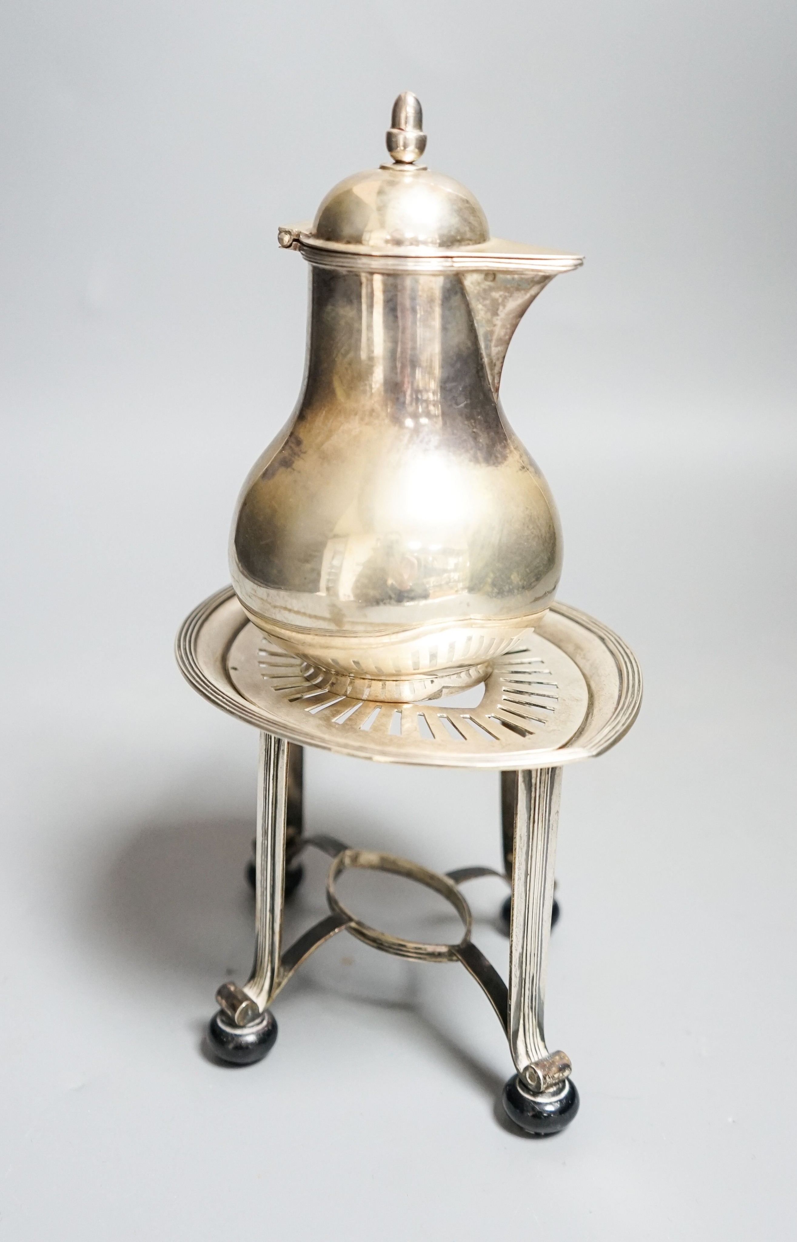 A Dutch white metal cafe-au-lait pot, with hinged cover, acorn finial and wooden handle, height 13cm, together with a Dutch white metal stand, gross 9.5oz.